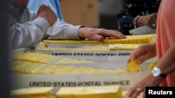 Para petugas pemilu di pusat penghitungan suara di Cobb County, Marietta, Georgia, tampak menyusun surat suara setelah pemungutan suara pemilu paruh waktu AS ditutup pada 8 November 2022. (Foto: Reuters/Cheney Orr) 