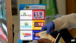 Seorang pelanggan diberikan tiket Powerball yang dibeli di Lichine's Liquor & Deli di Sacramento, California, Senin, 7 November 2022. Pengundian Senin malam diperkirakan mencapai rekor $1,9 miliar. (Foto: AP/Rich Pedroncelli)