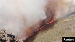 Wildfires burn on Tanzania's Mount Kilimanjaro, Oct. 29, 2022 in this still image taken from social media video. 