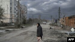 An old woman walks in the Kherson region village of Arkhanhelske, Nov. 3, 2022.