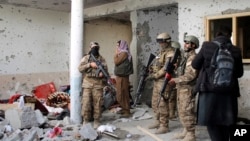 Tentara Taliban memeriksa sebuah rumah setelah baku tembak dengan ISIS selama 8 jam di tempat yang diduga sebagai tempat persembunyian militan ISIS di pinggiran Jalalabad, timur Kabul, Afghanistan, Selasa, 30 November 2021. (Foto: AP)