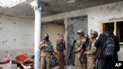 Para kombatan Taliban memeriksa sebuah rumah setelah baku tembak selama delapan jam antara Taliban dan ISIS saat Taliban menggerebek persembunyian militan ISIS di luar Jalalabad, timur Kabul, Afghanistan, 30 November 2021. (Foto: Shir Shah Hamdard/AP Photo)