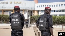 FILE - Police officers stand in front of the courthouse where opposition leader Ousmane Sonko is appearing for a hearing in Dakar, Senegal, Nov. 3, 2022. Senegalese journalist Pape Ale Niang was arrested after publishing articles about rape charges facing Sonko. 