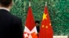 中国和瑞士官员会谈前，中国工作人员正在布置会场。桌上摆放的和背景是中国和瑞士两国国旗。