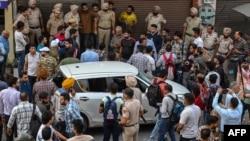 Police and onlookers gather at the site where Shiv Sena leader Sudhir Suri was shot dead by an unidentified assailant while protesting in front of a temple in Amritsar, India, on Nov. 4, 2022. 