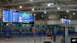 File - Seorang penumpang mengenakan masker di tengah pandemi COVID-19, berjalan di Bandara Internasional Eleftherios Venizelos yang kosong selama pemogokan 24 jam di sektor publik di Athena, Kamis, 15 Oktober 2020. (AP/Thanassis Stavrakis)
