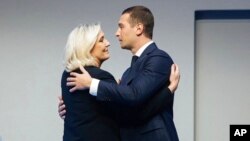 French far right leader Marine Le Pen celebrates with newly elected chief of the National Rally president Jordan Bardella during the party congress in Paris, Nov. 5, 2022.