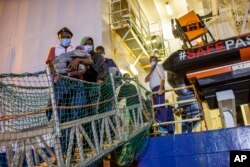 Migrants disembark from the Norway-flagged Geo Barents rescue ship carrying 572 migrants in Catania's port, Sicily, southern Italy, Oct. 6, 2022.