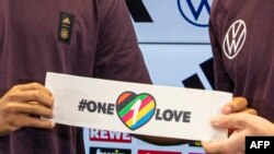 FILE - Two of Germany's players present the captain's armband — a symbol against discrimination and for diversity — in Frankfort, Sept. 21, 2022. FIFA banned the wearing of this armband because Qatar's laws are strongly against non-heterosexual expression. 