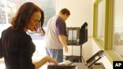 ARCHIVO: un empleado del condado de Boone programa una máquina contadora de boletas de ES&S en una sala de capacitación de jueces electorales en Columbia, Missouri, el 20 de octubre de 2006.