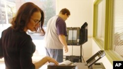 FILE - A Boone County employee programs an ES&S ballot counting machine in an election judge training room in Columbia, Missouri, on Oct. 20, 2006.