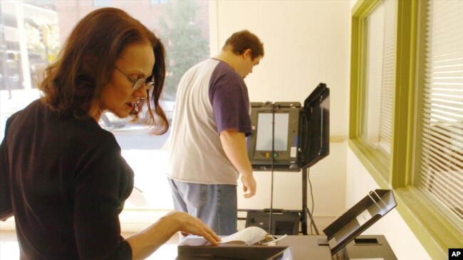FILE - A Boone County employee programs an ES&S ballot counter machine at an election judge training room in Columbia, Missouri, Oct 20, 2006.