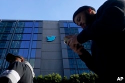 Orang-orang berjalan di luar markas Twitter di San Francisco, Jumat, 4 November 2022. (Foto: AP)