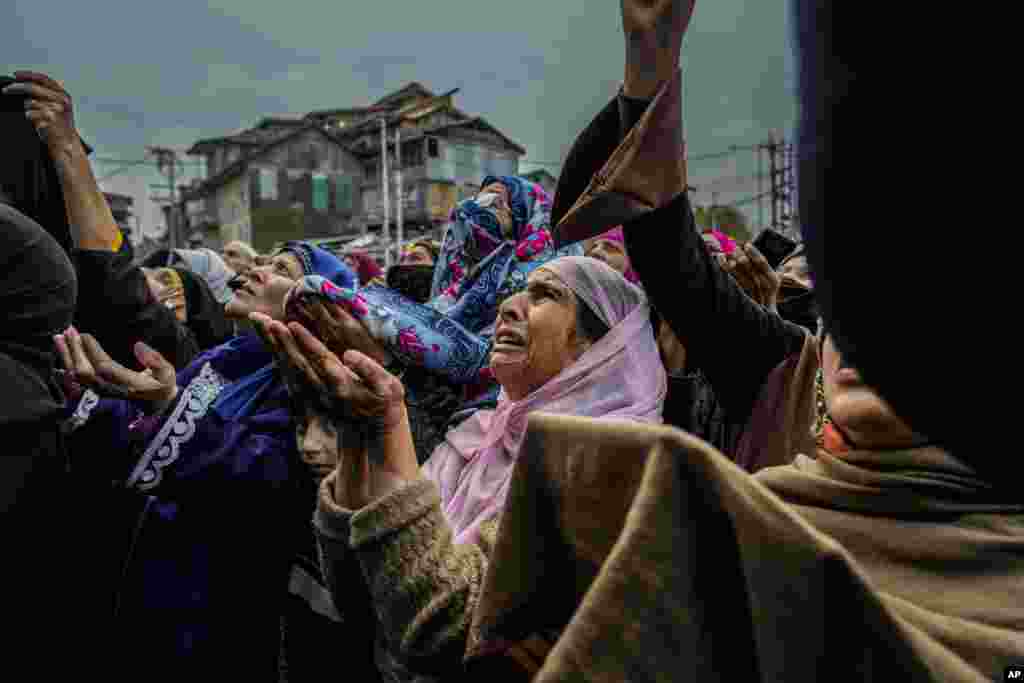 Kashmiri Muslim women devotees pray as a priest shows a relic of Sufi saint Sheikh Syed Abdul Qadir Jeelani outside his shrine in Srinagar, Indian-controlled Kashmir.