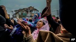 Kashmiri Muslim women devotees pray as a priest displays a relic of Sufi saint Sheikh Syed Abdul Qadir Jeelani outside his shrine in Srinagar, Indian-controlled Kashmir.