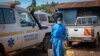 A man wearing protective clothing carries water to wash the interior of an ambulance used to transport suspected Ebola patients, in the town of Kassanda, Uganda, Nov. 1, 2022.