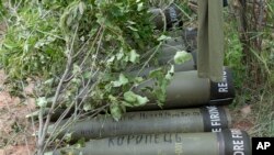 FILE - U.S.-supplied M777 howitzer shells lie on the ground to fire at Russian positions in Ukraine's eastern Donbas region, June 18, 2022. The writing on one of them reads in Ukrainian: "Nothing is forgotten."
