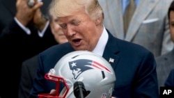 FILE - President Donald Trump is presented with a New England Patriots football helmet by Patriots coach Bill Belichick and Patriots owner Robert Kraft during a ceremony on the South Lawn of the White House in Washington, April 19, 2017.