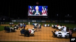 People watch Democratic presidential candidate and former Vice President Joe Biden speak at a watch party for the Democratic National Convention at Dunkin' Donuts Park, home of the minor league baseball team the Hartford Yard Goats, Thursday, Aug…