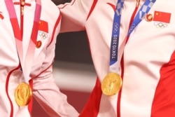 中国场地自行车女子团体赛两名金牌得主在东京奥运会领奖台上违反奥林匹克宪章，佩戴中共前领导人毛泽东的像章。（2021年8月2日）