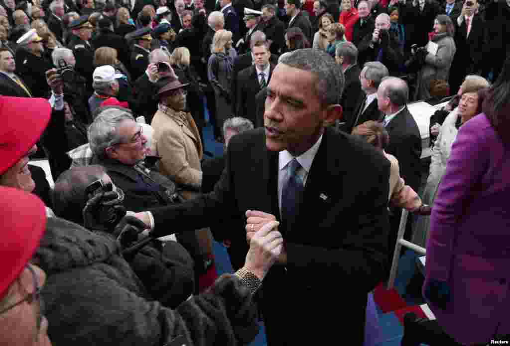 U.S. President Barack Obama greets people as he exits following the ceremonial swearing-in at the presidential inauguration on the West Front of the U.S. Capitol in Washington January 21, 2013