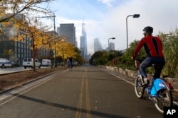 A cyclist rides along the reopened West Side bike path, Nov. 2, 2017, in New York, where a man in a rented pickup truck mowed down pedestrians and cyclists along the busy bike path on Tuesday, killing several and seriously injuring others.