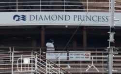 Seorang pekerja dengan alat pelindung berjalan di atas kapal pesiar Diamond Princess di Pelabuhan Yokohama, selatan Tokyo, Jepang, 20 Februari 2020. (Foto: Reuters/Athit Perawongmetha)