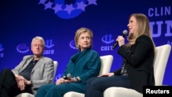 FILE - Former president Bill Clinton (L) and former secretary of state and Democratic presidential candidate Hillary Clinton (C) listen to their daughter and vice chair of the Clinton Foundation Chelsea Clinton during an event sponsored by the foundation in Tempe, Arizona, March 22, 2014. 