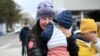 A Ukrainian refugee holding her child cries after she arrived at the Siret border crossing between Romania and Ukraine on April 18, 2022. (Daniel MIHAILESCU / AFP)