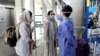 A health worker, right, checks temperature of passengers to help prevent the spread of the coronavirus upon arrival at the departure terminal of Tehran's Imam Khomeini airport, Iran, Friday, July 17, 2020. The first Emirates flight arrived in Iran…