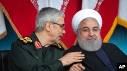 Presidensi Iran, Presiden Hassan Rouhani, kanan, mendengarkan Kepala Staf Umum Angkatan Bersenjata Mohammad Hossein Bagheri. (Foto: AP)