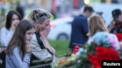 Seorang wanita menangis di dekat tugu peringatan korban penembakan mematikan di sekolah di Kazan, Rusia, 11 Mei 2021. Pada 20 September, sebuah penembakan di sebuah kampus di Rusia menewaskan 5 orang. (Foto: REUTERS/Artem Dergunov)