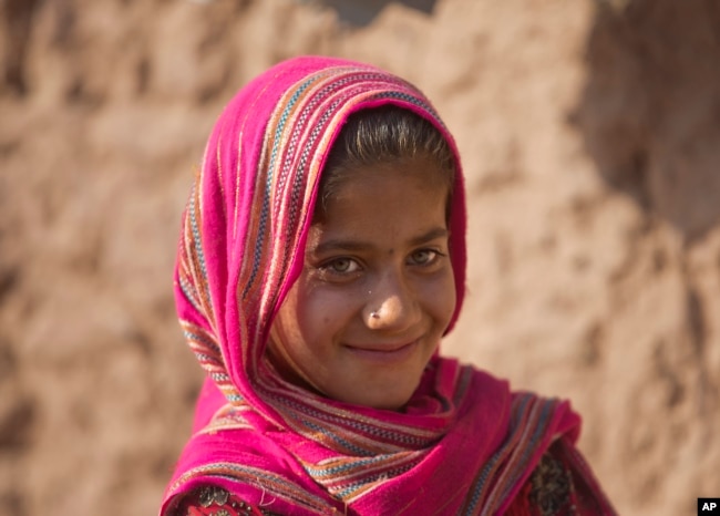 Zarmina, una niña de Afganistán, que huyó de su pueblo con su familia debido a la guerra y la hambruna, camina en un campamento de refugiados, en un suburbio de Islamabad, Pakistán, el martes 19 de junio de 2018.