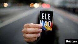 A demonstrator shows a sticker that reads "Not him" during a protest against Brazilian presidential candidate Jair Bolsonaro at Paulista Avenue in Sao Paulo, Brazil, Oct. 6, 2018.