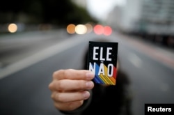 A demonstrator shows a sticker that reads "Not him" during a protest against Brazilian presidential candidate Jair Bolsonaro at Paulista Avenue in Sao Paulo, Brazil, Oct. 6, 2018.