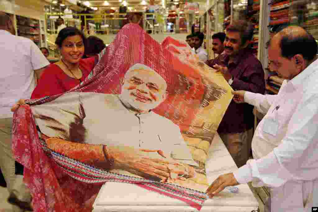 A woman holds a sari printed with a portrait of Bharatiya Janata Party&#39;s prime ministerial candidate Narendra Modi at a garments shop in Mumbai, May 14, 2014.