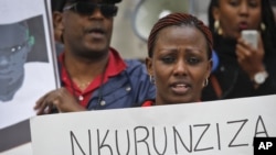 FILE - A protester holds up a poster as Burundi nationals from across the U.S. and Canada, along with supporters, demonstrate outside U.N. headquarters, calling for an end to atrocities and human rights violations in Burundi under the government of President Pierre Nkurunziza, April 26, 2016, in New York. 