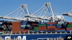 FILE - In this Oct. 26, 2016, photo, a container ship waits to be unloaded at the Port of Oakland, as seen from Alameda, Calif. 