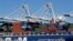 FILE - In this Oct. 26, 2016, photo, a container ship waits to be unloaded at the Port of Oakland, as seen from Alameda, Calif. 