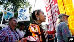 Angela Miracle Gladue, center, a member of the Frog Lake First Nations, a Cree community in Edmonton, Alberta, Canada, attends a rally in support of the Standing Rock Sioux Tribe and in opposition of the Dakota Access oil pipeline, in Lafayette Park near the White House, Sept. 13, 2016, in Washington.