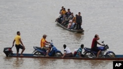 Venezolanos cruzan el río Arauca, la frontera natural entre Venezuela y Colombia, para refugiarse en Arauquita, Colombia, el viernes 26 de marzo de 2021.