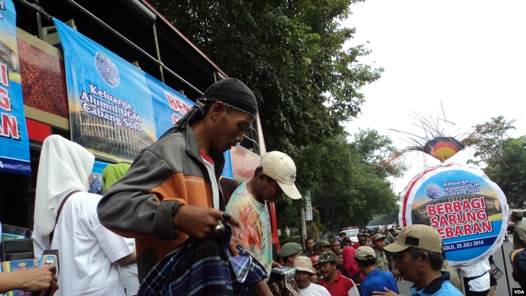 Para tukang becak di Solo mencoba sarung baru yang dibagikan kepada mereka oleh Keluarga Alumni Mahasiswa Gadjah Mada dalam rangka Lebaran (25/7) 