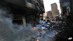 Egyptians gather next to a building belonging to Christians that was set on fire during clashes between Muslims and Christians in the Imbaba neighborhood of Cairo, May 8, 2011