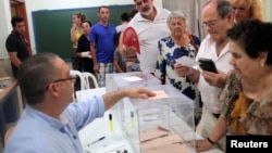 A man prepares to cast his vote in Spain's general election at a polling station in Rincon de la Victoria, June 26, 2016.