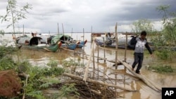 A Cambodian man walks on a bridge from his fishing wooden boat at Mekong river bank near Phnom Penh, Cambodia, July 27, 2011