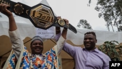 Le Camerounais Francis Ngannou, champion du monde des arts martiaux mixtes poids lourds (à g.), à Bafoussam, au Cameroun, le 1er mai 2021.