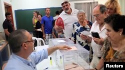 FILE - A man prepares to vote in Spain's general election at a polling station in Rincon de la Victoria, June 26, 2016.