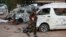 A soldier walks past damaged buses following an explosion at a bus park in Abuja, Nigeria, April. 14, 2014. 
