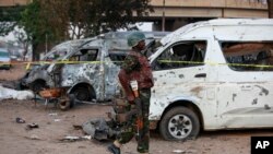 一名军人走在尼日利亚阿布贾公共汽车站的爆炸现场。（2014年4月14日）
