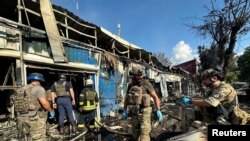 6일 우크라이나 동부 도네츠크주 코스티안티니우카 시내 공습 현장을 경찰과 구조대원들이 살펴보고 있다.